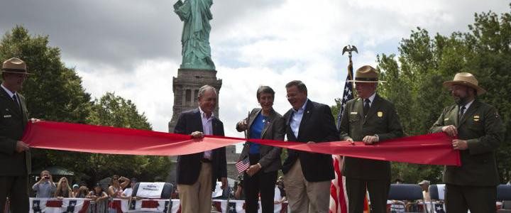Michael Bloomberg, coupant un ruban symbolique lors de la cérémonie de réouverture de la Statue de la Liberté et de Liberty Island.